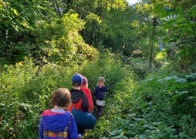 Children walking single file through the greenery